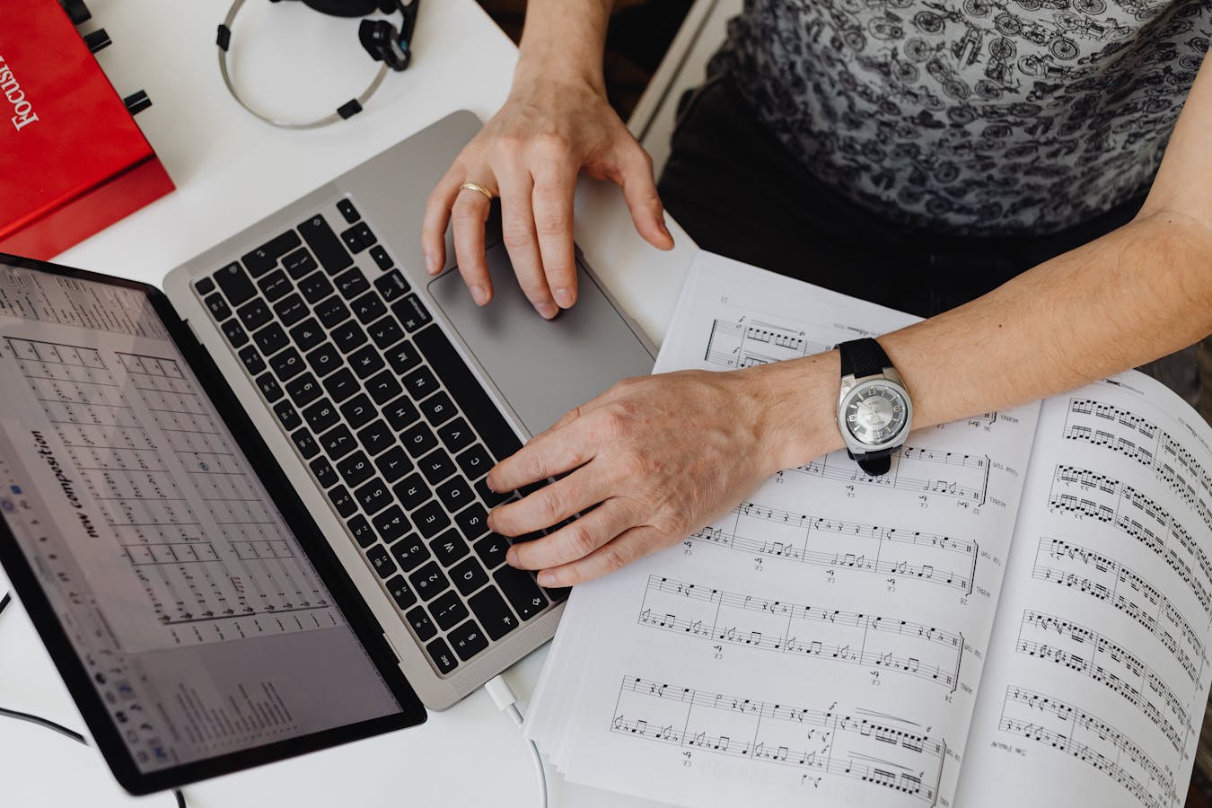 Musicien travaillant sur son ordinateur avec des partitions