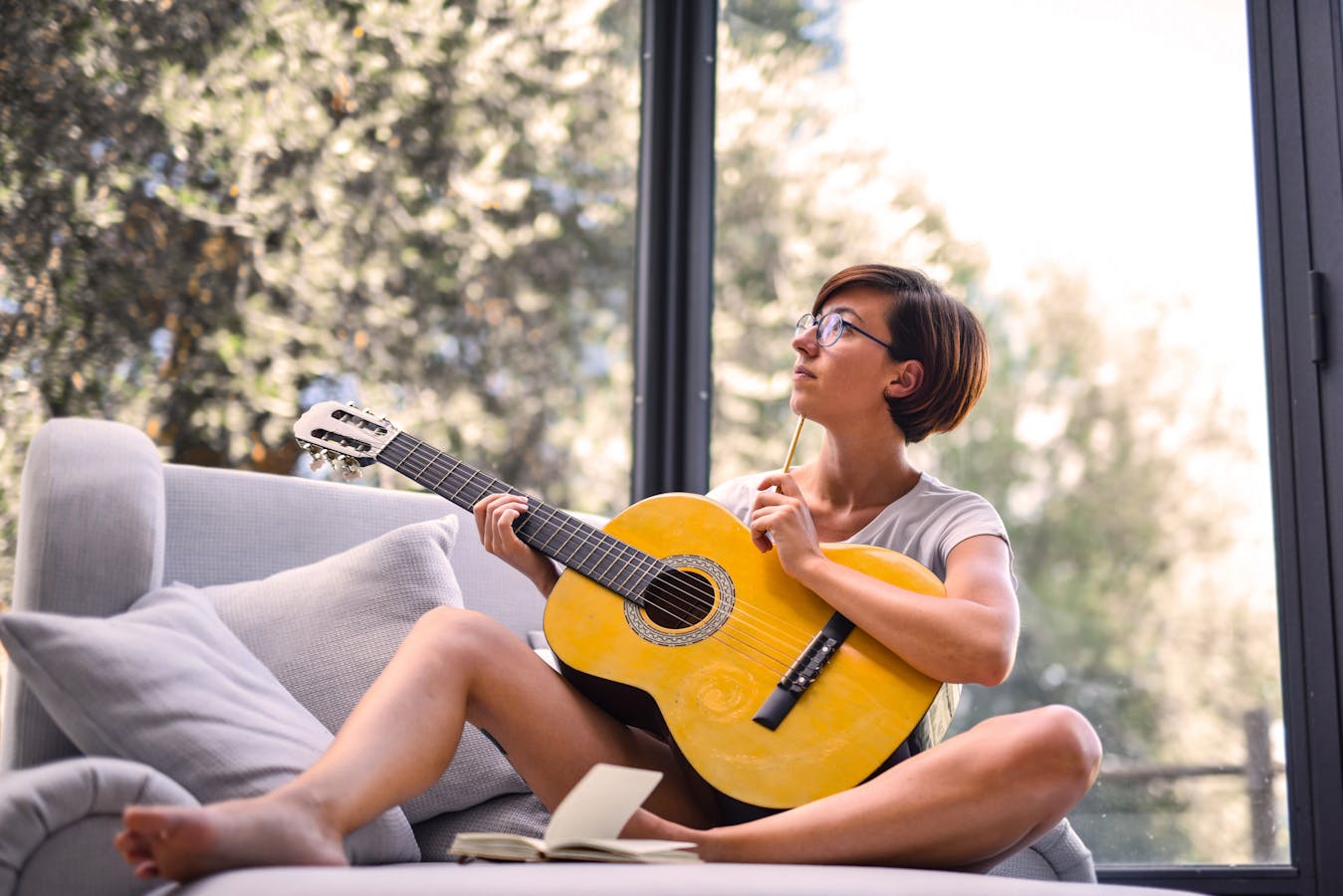 Femme jouant de la guitare pensivement